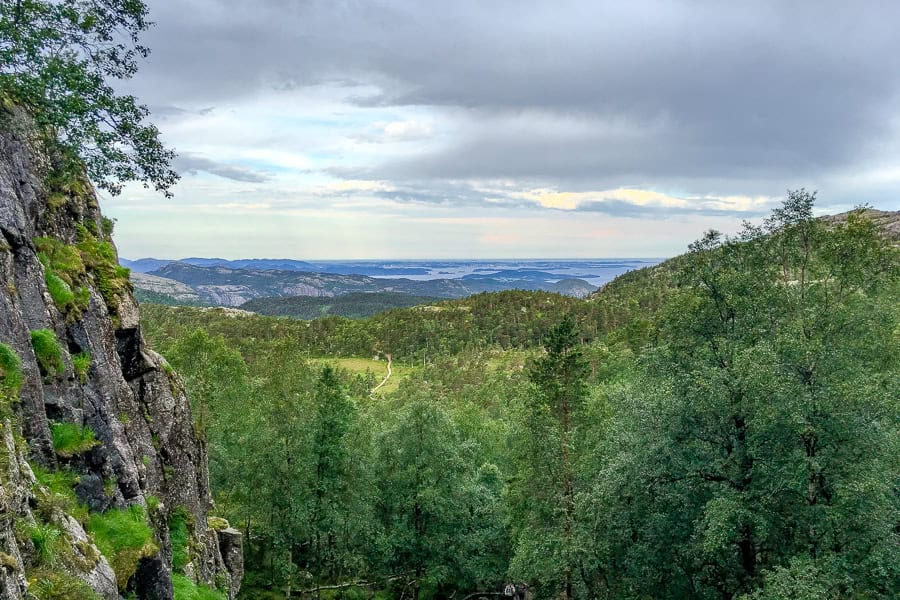 Views over trees towards mountains and lakes while hiking Preikestolen.