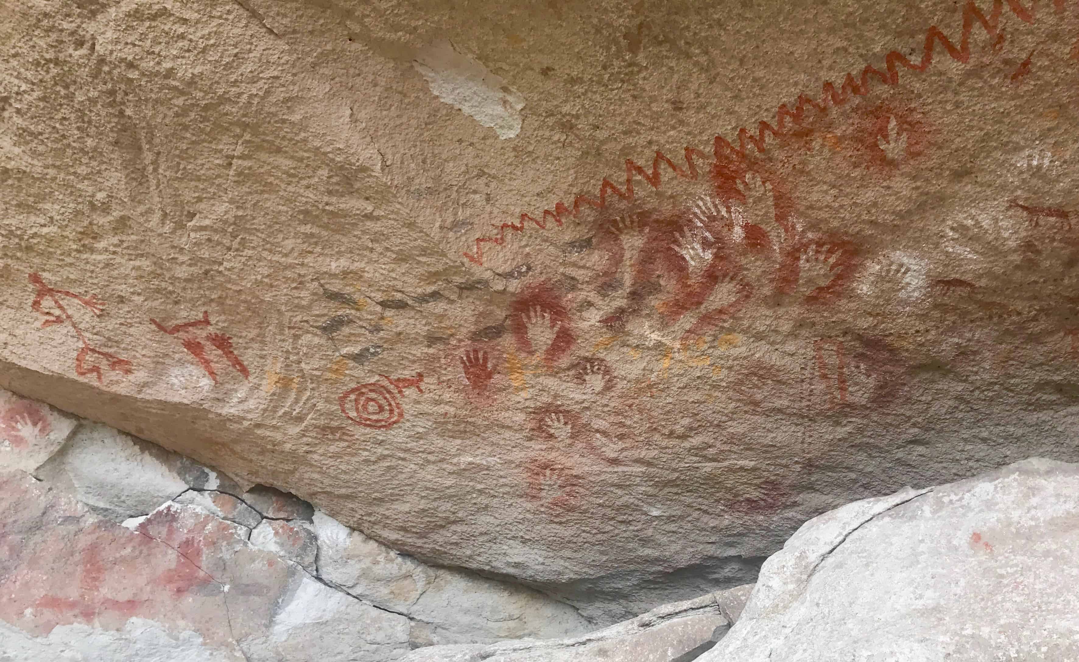 Rock painting of the famous Dancer alongside geometric patterns at Cueva de Las Manos
