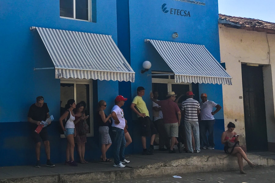 Cuba trip planning: A queue of people wait to buy wifi cards at a blue shop.