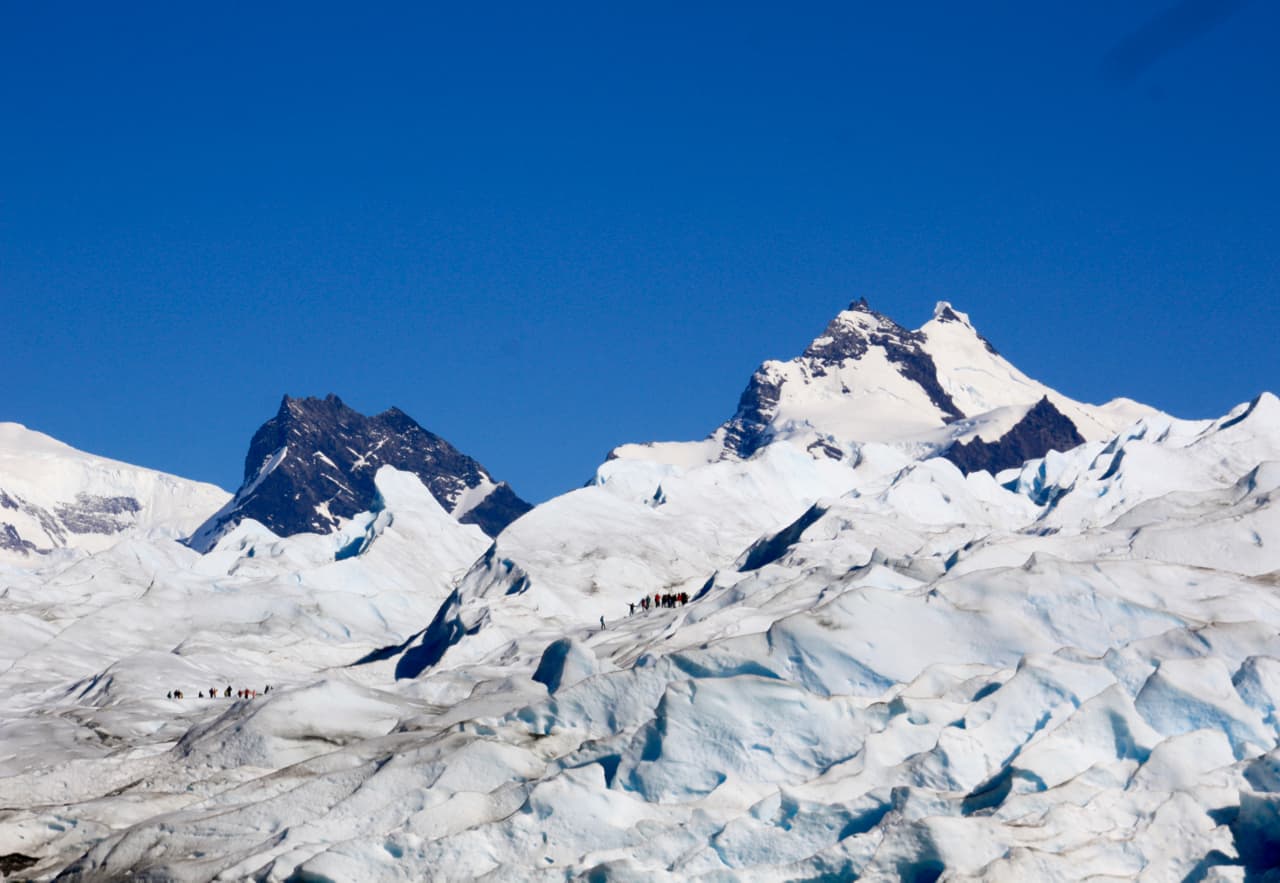 Two groups of tourists hike up onto the ice on a visit to Perito Moreno Glacier.