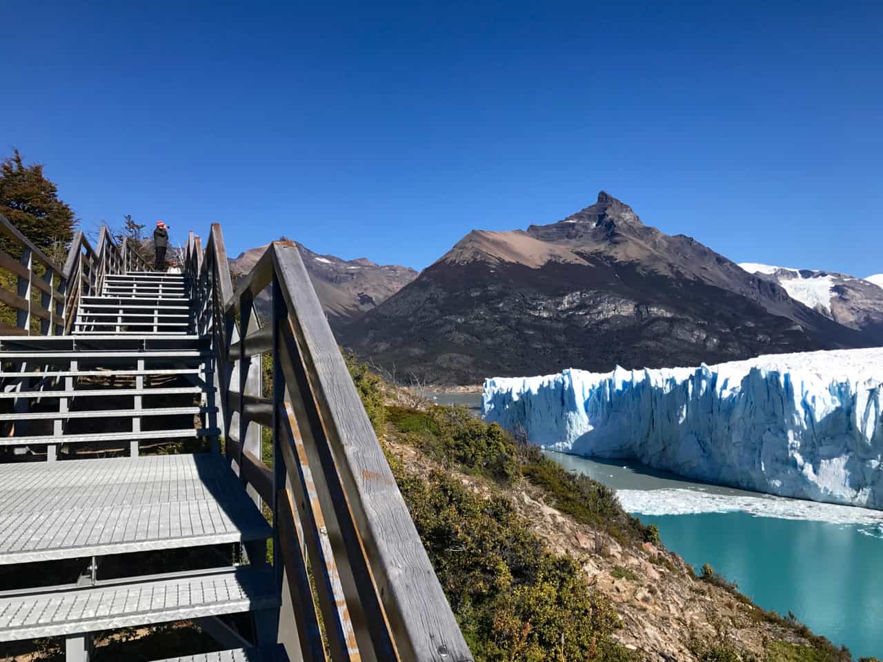 A guy photographs the Perito Moreno Glacier from one of the park's walkway.