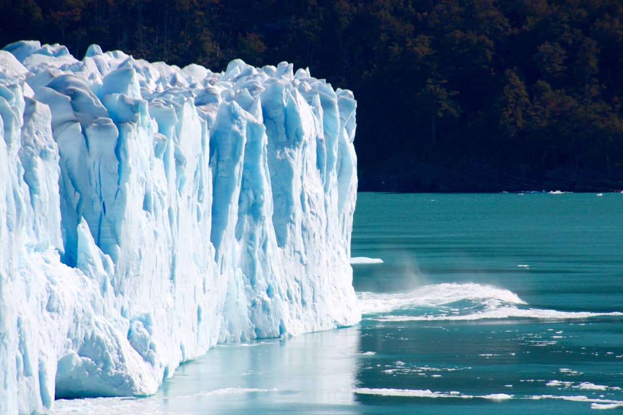 A wave surges out from the glacier wall on a visit to Perito Moreno Glacier.