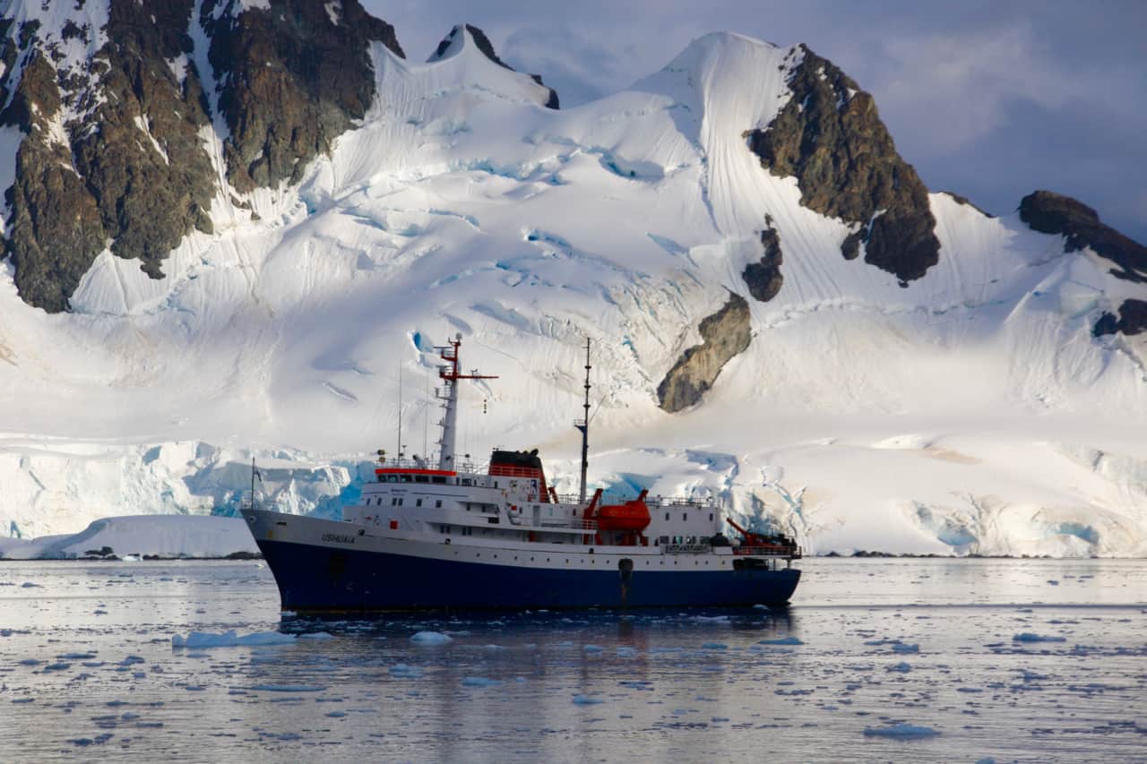 The expedition ship MV Ushuaia rests in a calm Antarctic bay.