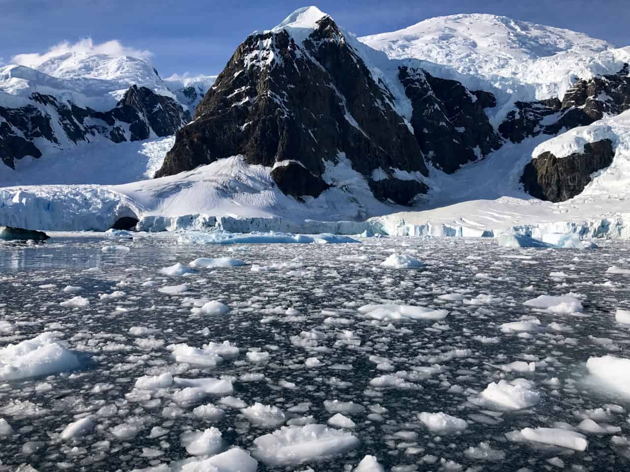 A slushy bay of ice leads to the marshmallow glacier and rocky peaks of Paradise Bay in Antarctica. 