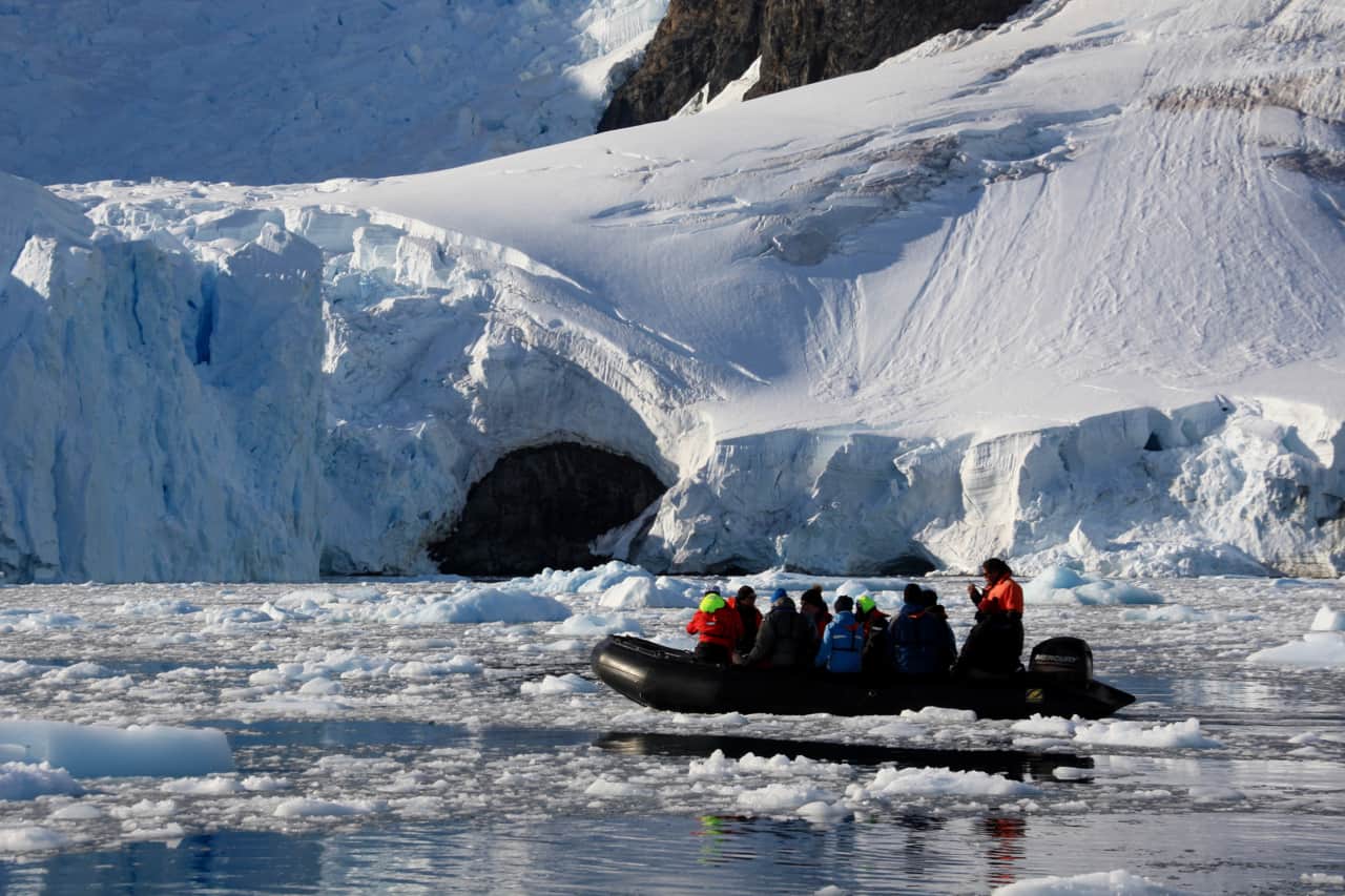 Travellers enjoy a zodiac cruise through the ice of Paradise Bay while visiting Antarctica.