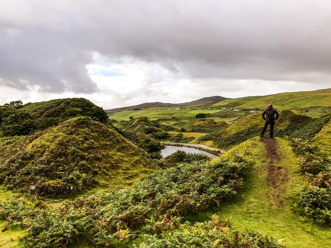 John stands on one of the small hills that scatter the Fairy Glen on Skye. 