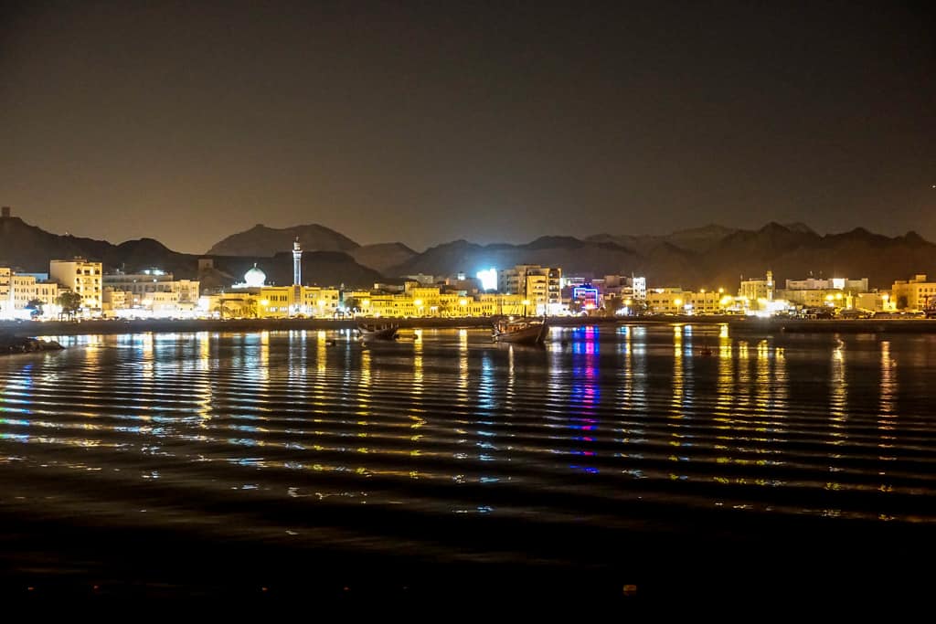 Oman city photos – Mutrah corniche at sunset complete with reflections across the harbour.