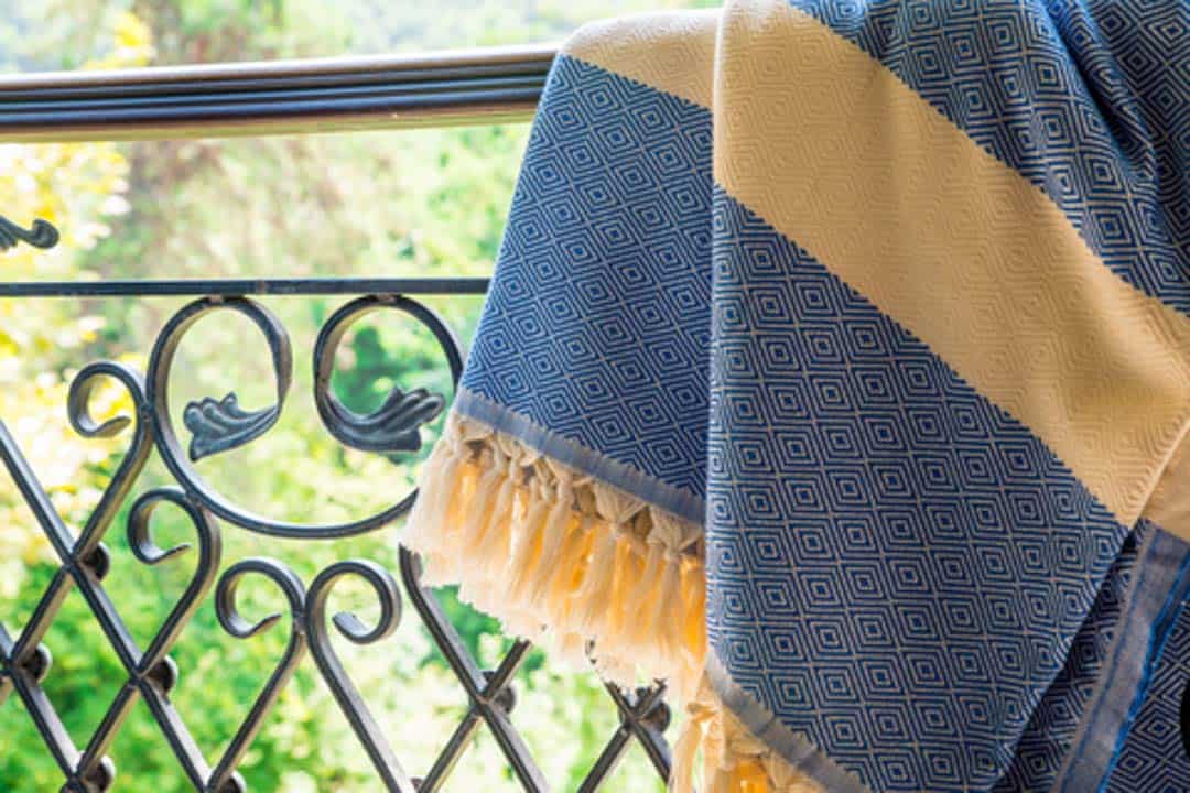 A Turkish pestemal towel, key component of the hammam experience, hangs on a railing. ©Adaptice Photography|Dreamstime.com