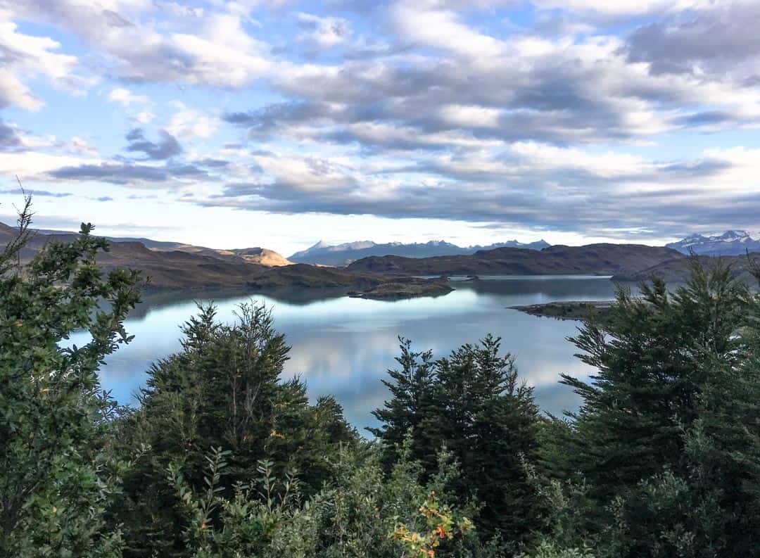 Clouds reflect off the mirror-still lake at Camping Francés in Torres del Paine.