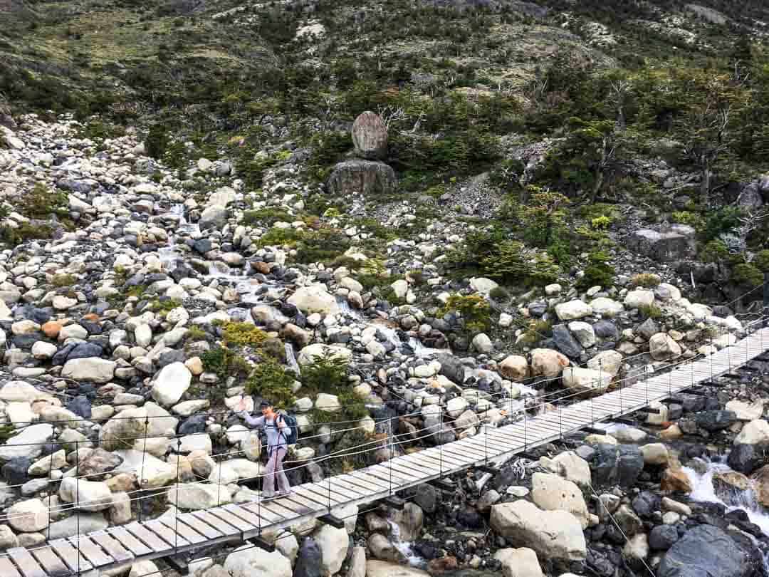 A swing bridge crosses a river on the W Trek in Torres del Paine.