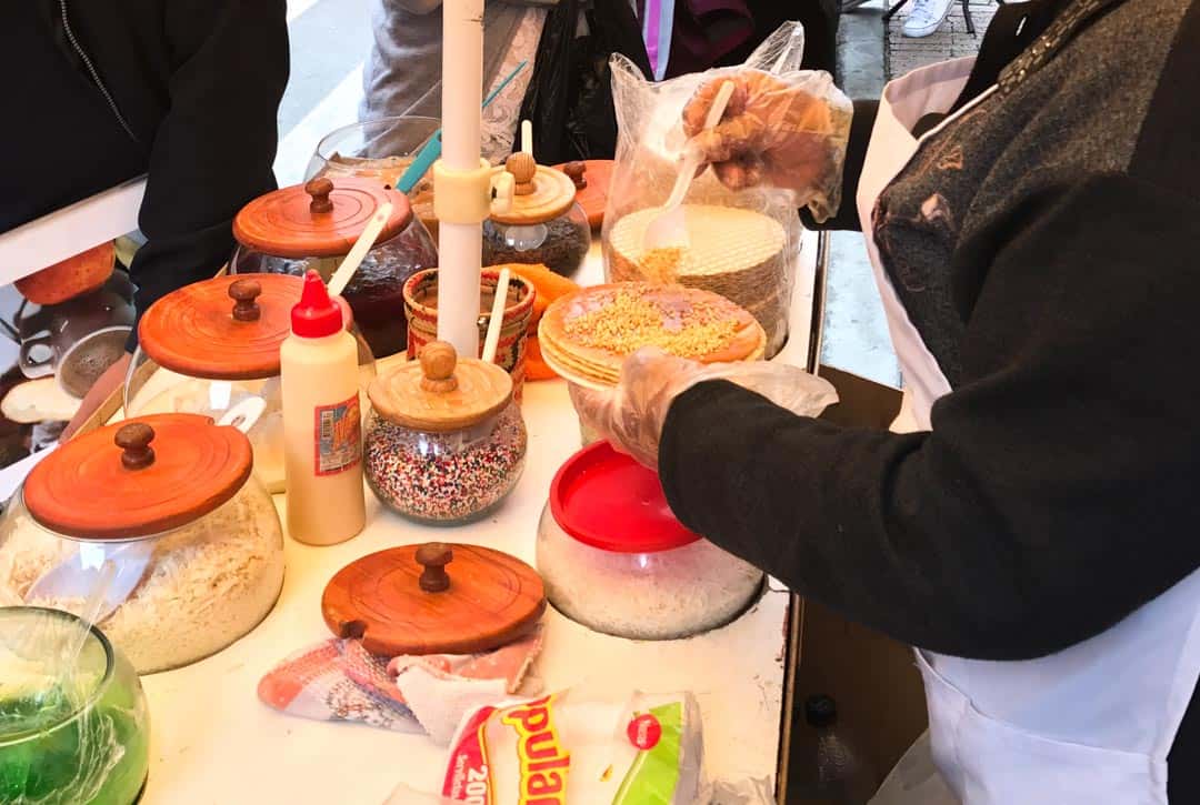 A stallholder puts together an oblea with dulce de leche and nuts.