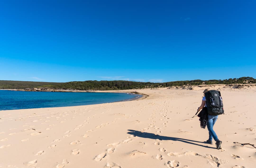 A hiker crosses the sand at Marley Beach on the Royal National Park Coast Track.