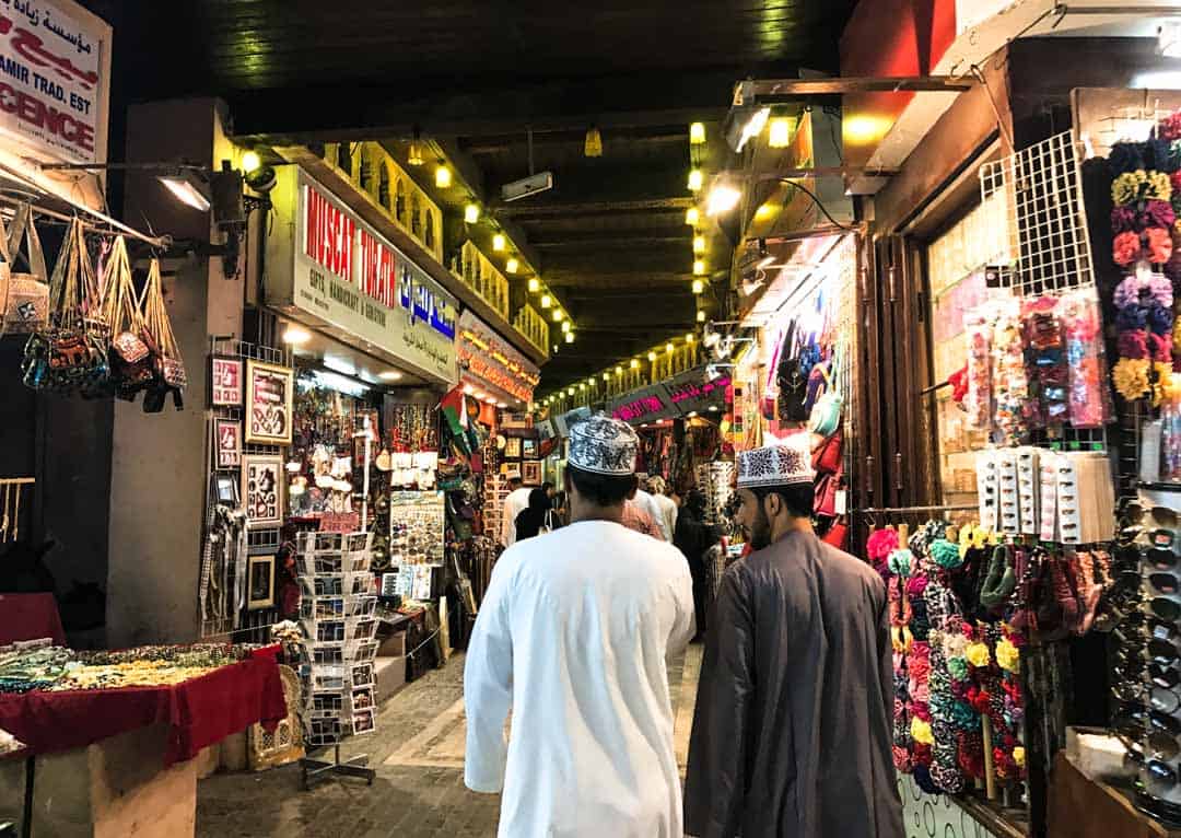Two men wander the famous Mutrah Souq, a colourful, frenetic place to visit on the Muscat leg of our Oman Itinerary.