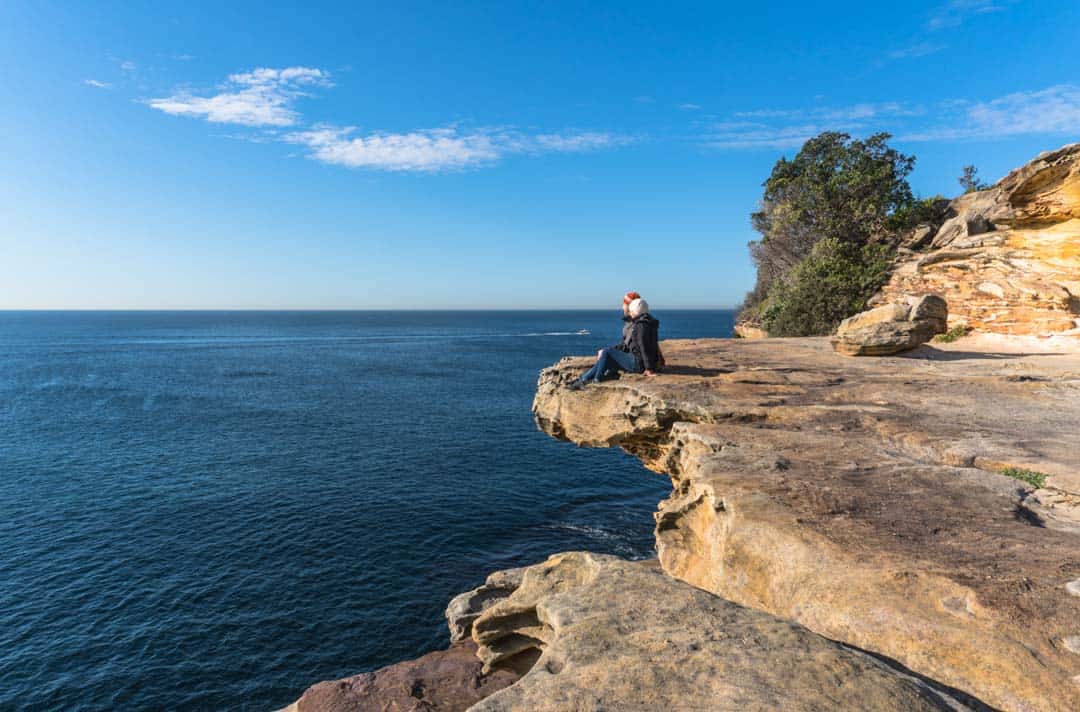 Couple Look Out Over Ocean From Cliffs At Bronte In Sydney Australia