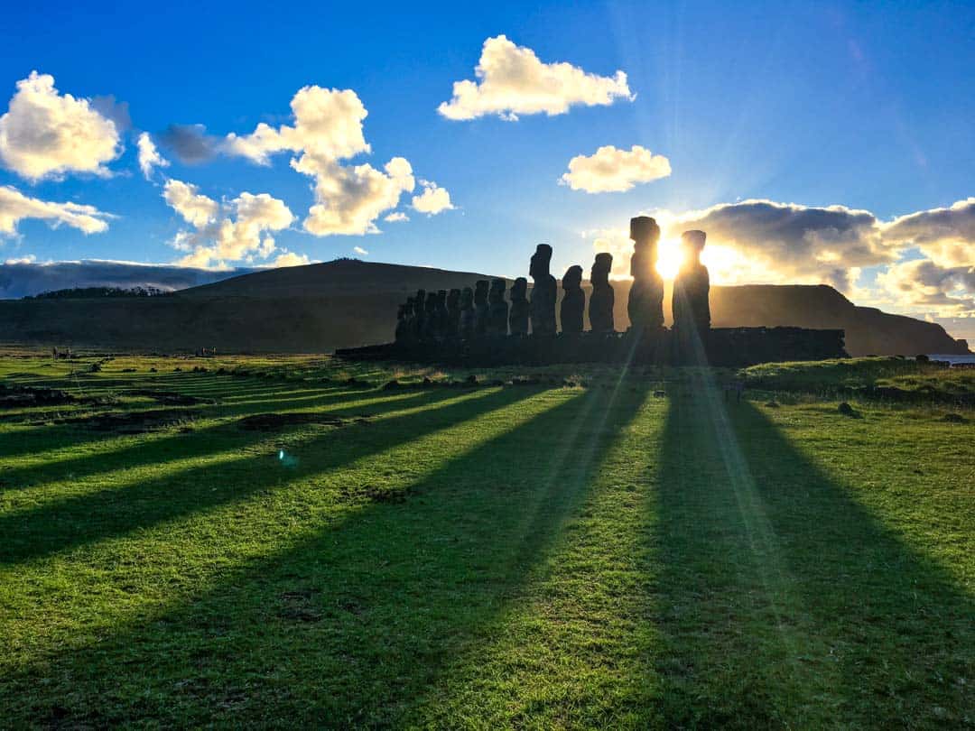 Sunrise casts rays between the giant moai of Ahu Tongariki, an Easter Island highlight.