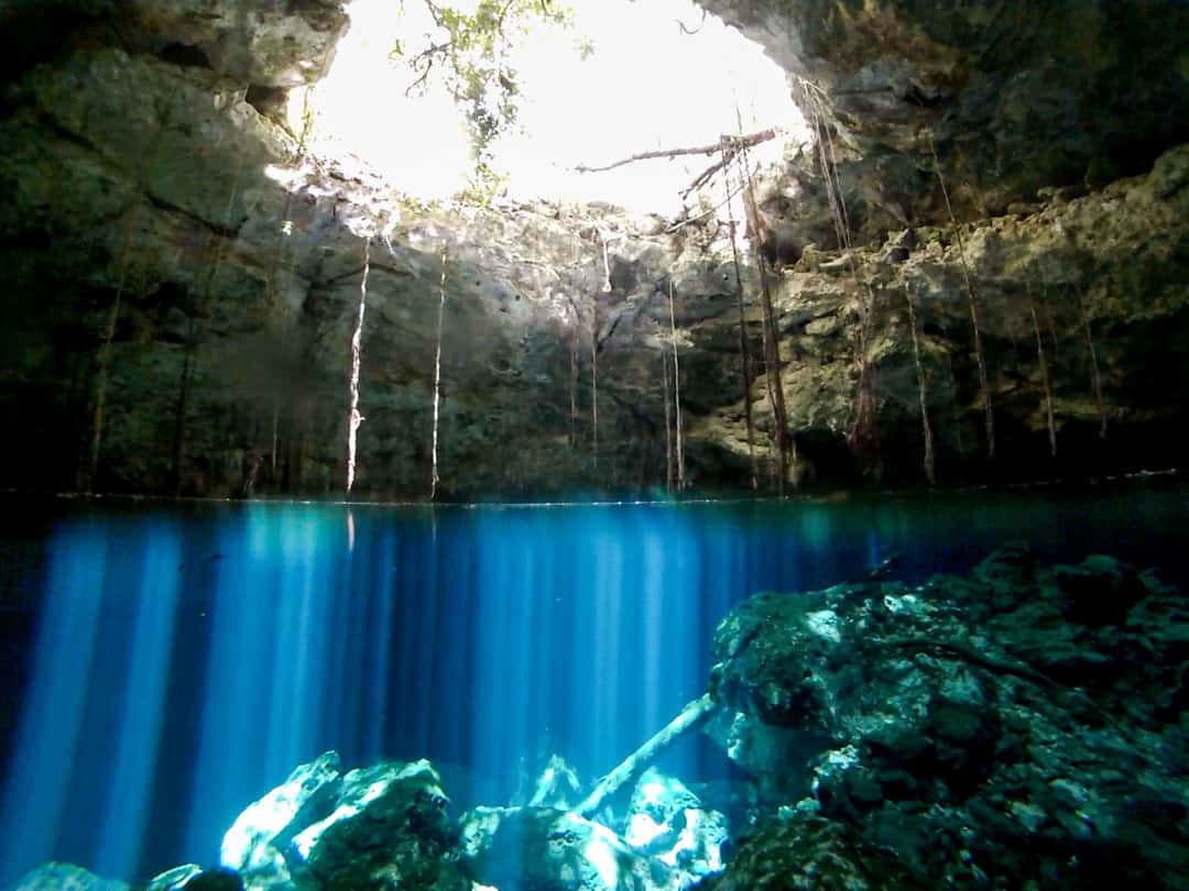 Light refracts beneath the water in Sugar Bowl Cenote, Mexico.
