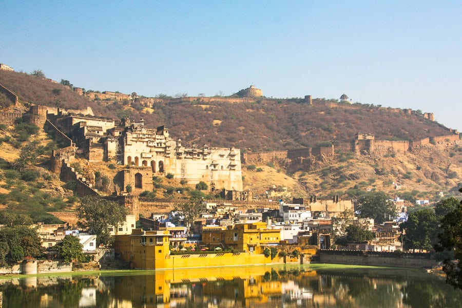 Imposing Bundi Palace and Fort reflecting off Nawal Sagar Lake during our Rajasthan road trip.