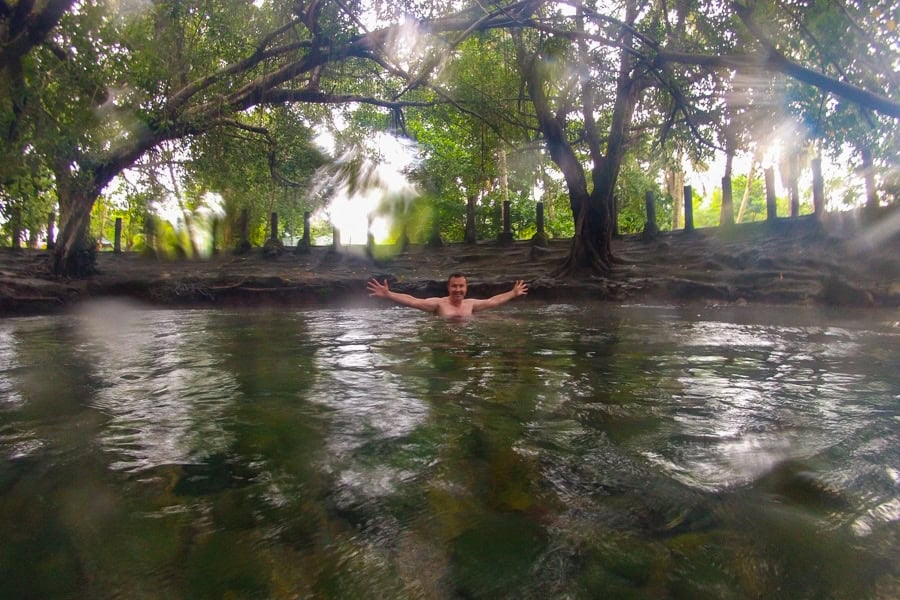 A visitor enjoys the warm waters of Mangeruda Hot Spring, a place not to miss on your Flores tour.