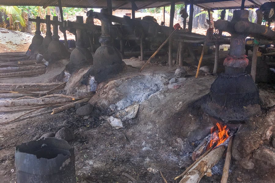 A line of traditional arak stills are heated by wooden fires in Aimere – one of the more interesting things to do in Flores.