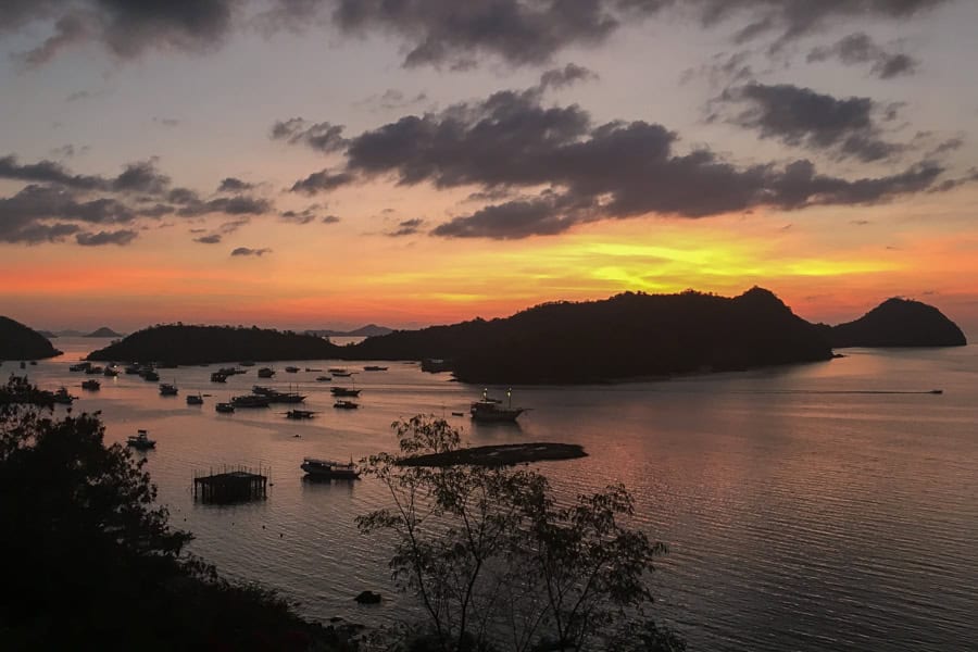 Views across the bay towards an orange sunset from Paradise Bar in Labuan Bajo, a must for any Flores Itinerary.