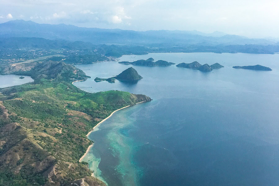 Views of offshore islands and beaches as we fly into Labuan Bajo on our Flores road trip and Komodo diving adventure.