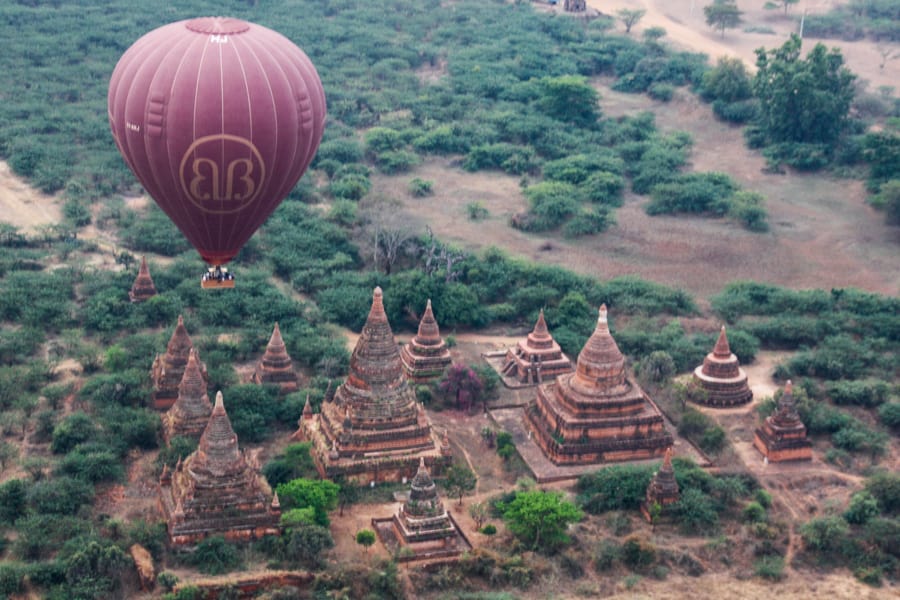Adventures around the world: A balloon floats above a cluster of temples in Bagan.