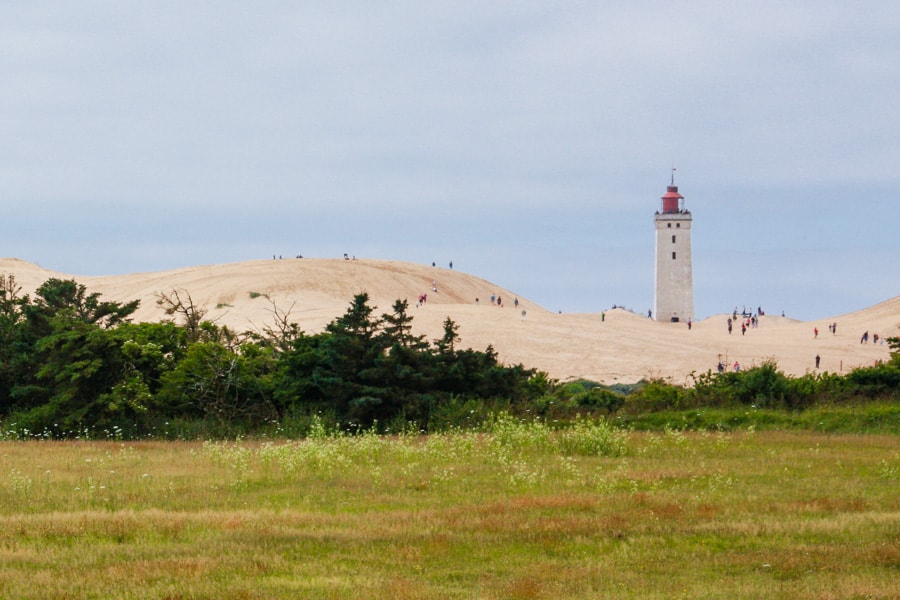 Road Trips in Europe: The 19th century Rubjerg Knude lighthouse rises above sand dunes in Denmark.
