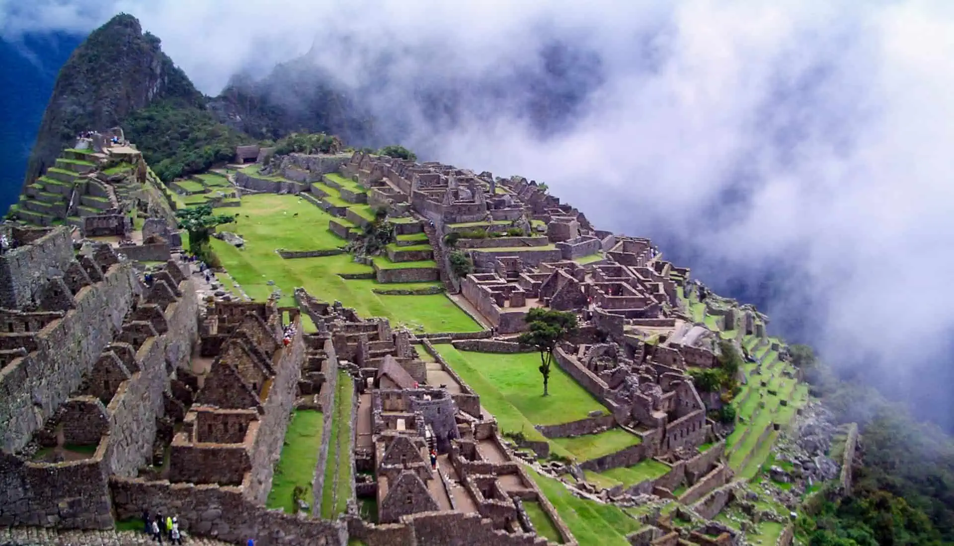 Epic Adventures - Mist drifts around mountaintop Macchu Picchu ruins.