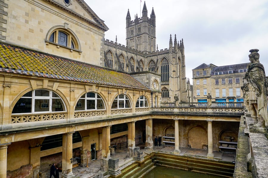 Looking down into an ancient Roman bath house surrounded by columns in Bath, one of the top things to do in south west England.