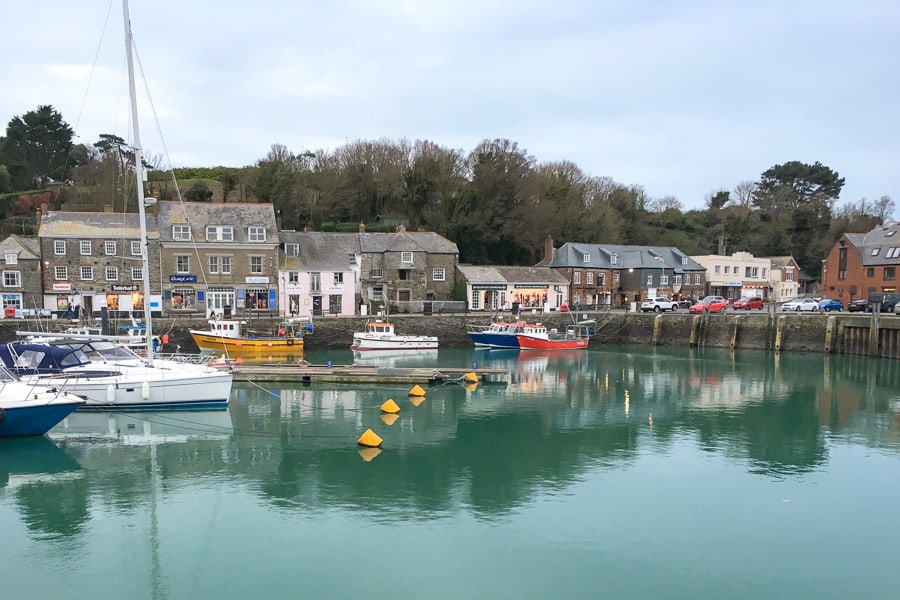 Boats in Padstow harbour with quaint old buildings in the background. 