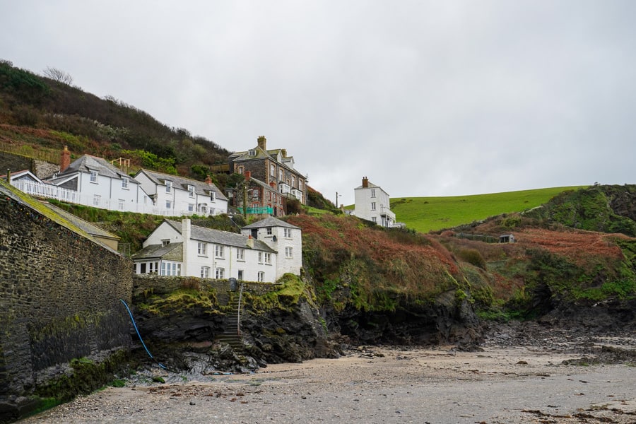 A group of white and stone houses on a hill above Port Isaac Harbour on our south west England itinerary.