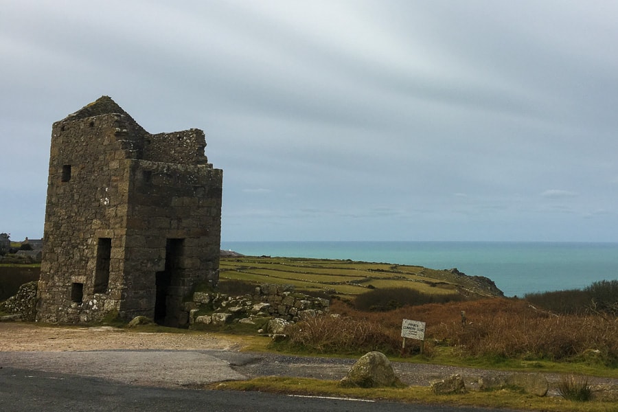 Cornwall Itinerary: The ruins of a stone tin mine building overlook fields to the sea.  