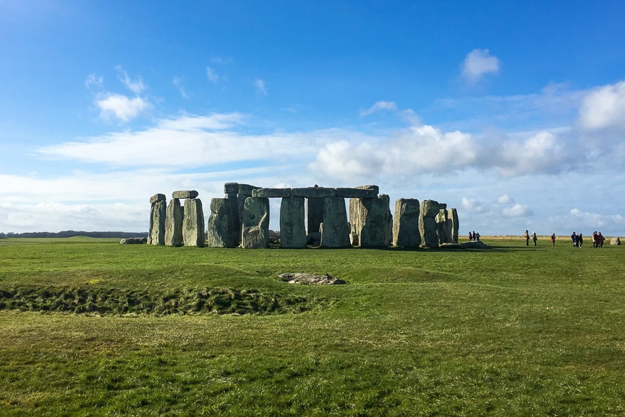 The tall standing stones of Stonehenge on a grassy field, one of the best things to do in south west England.
