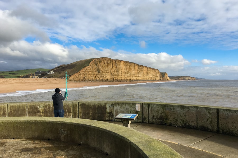 UK Road Trip Itinerary: The yellow east cliffs of West Bay rise above the beach.