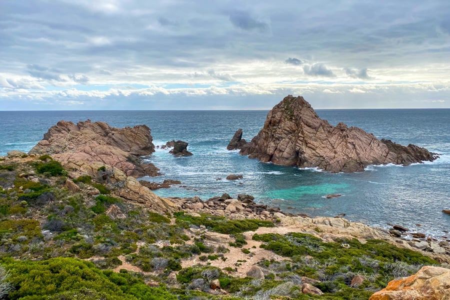 Clouds gather over the rugged island of Sugarloaf Rock, a top sunset spot on a south west Australia road trip.