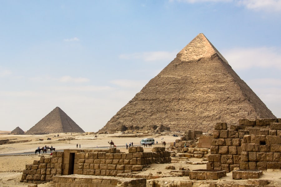 View of Great Pyramid of Giza with ruined stone buildings in foreground on our Cairo itinerary. 