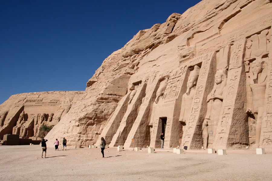 Egypt itinerary - Colossal statues stand guard outside the Temple of Hathor with part of the Temple of Ramses II in the background.