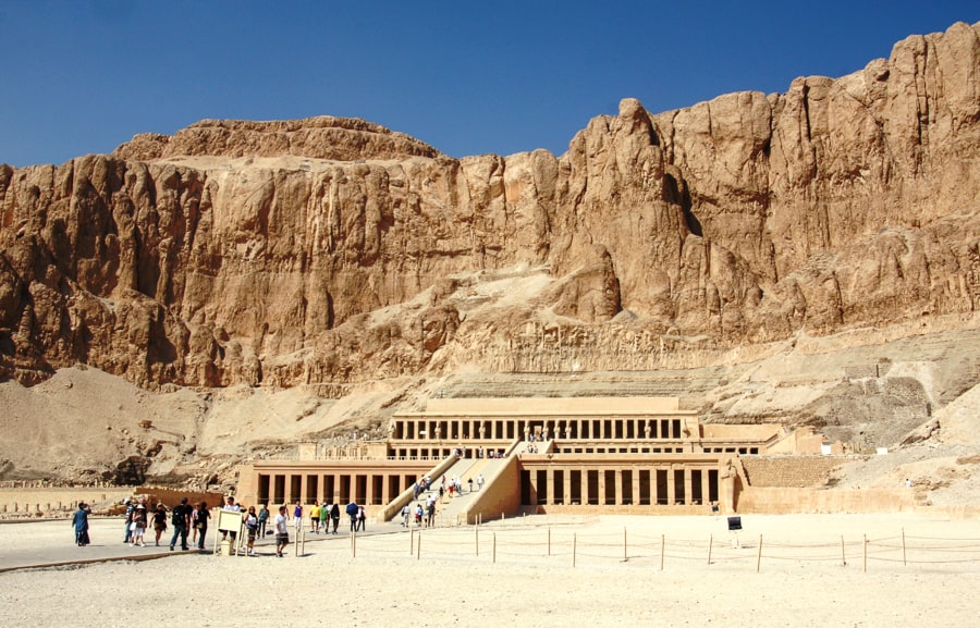 Ramps lead up to the vast, tiered temple of Hatshepsut with the high cliffs of Deir el-Bahri rising behind. 
