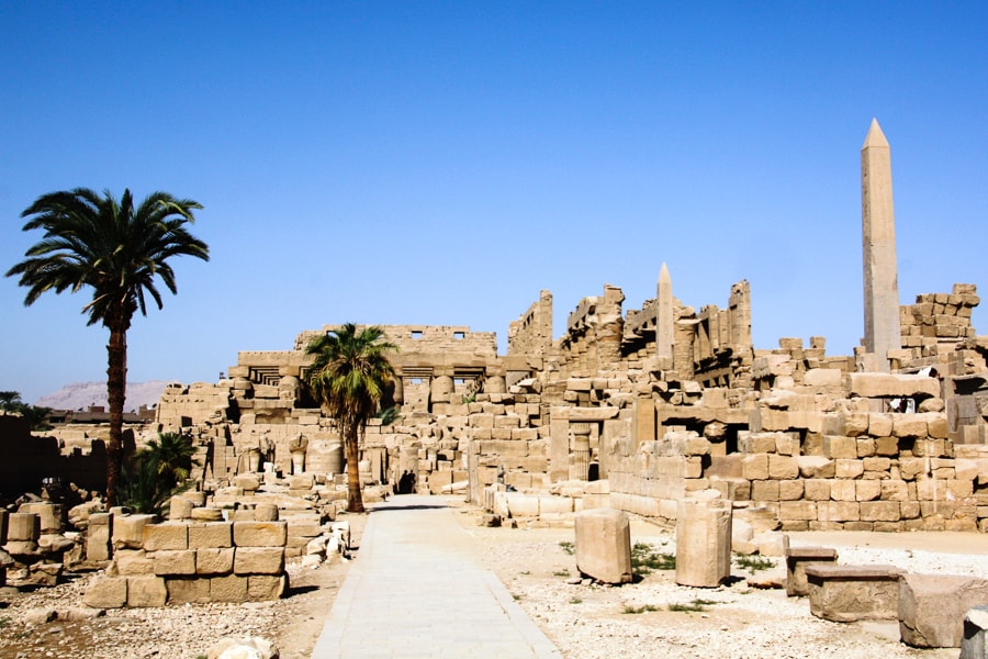 Two obelisks and rows of columns rise from within the ruins of immense Karnak Temple, a major stop on our 2 week Egypt itinerary.