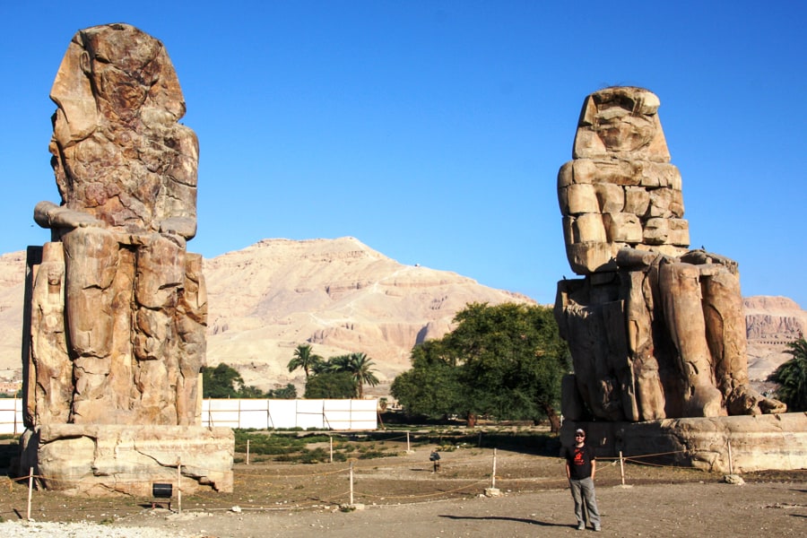 John is dwarfed by two eroded colossal statues of Amenhoptep III in the Luxor West Bank on our Egypt itinerary. 
