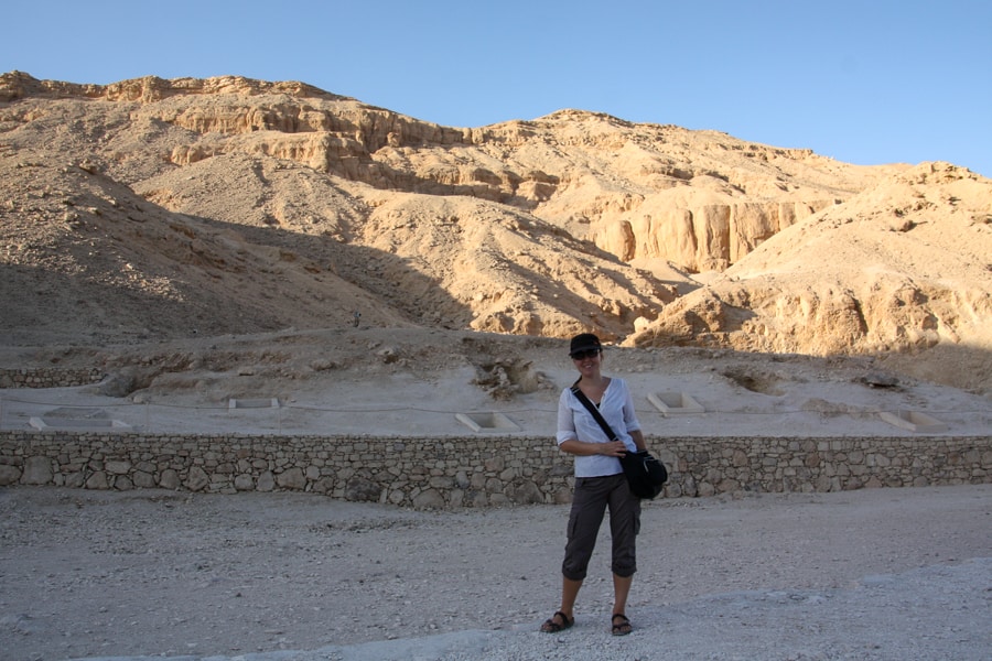 Dan stands on a path with dry, rocky mountains rising behind in the Valley of the Kings. 