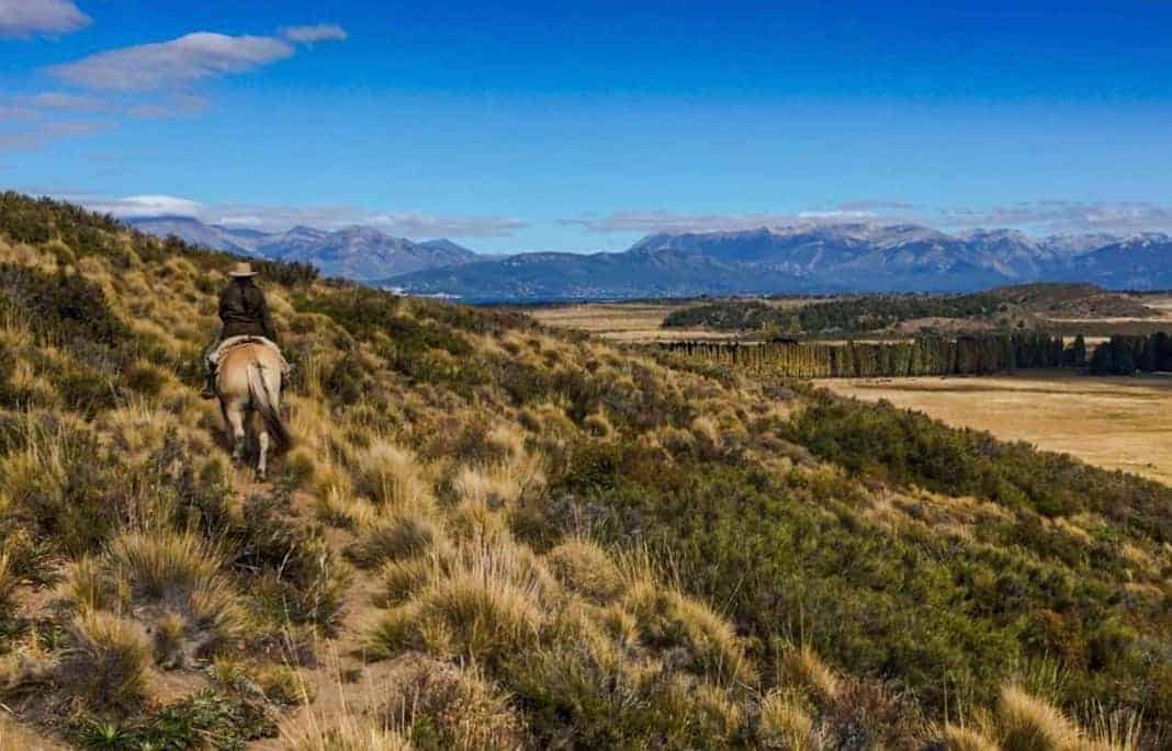 A horse ride through the countryside near Bariloche Argentina, offers up scenic panoramas towards distant peaks.