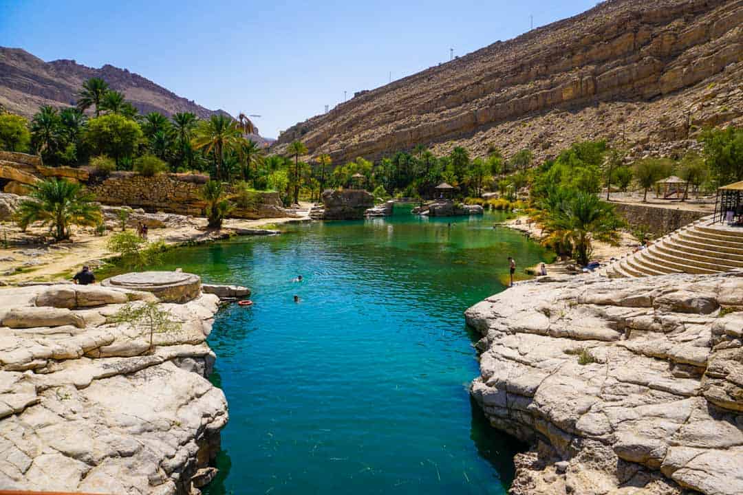 The emerald waters of Wadi Bani Khalid surrounded by a rocky landscape, one of our Oman Highlights.