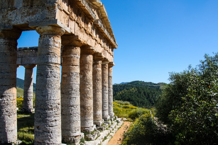 The great Doric Temple at Segesta Archaeological Park, with green hills rising and falling in the background.  