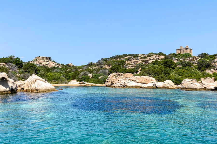 Swimmers enjoy the crystal clear waters of a secluded cove in the La Maddalena Archipelago.