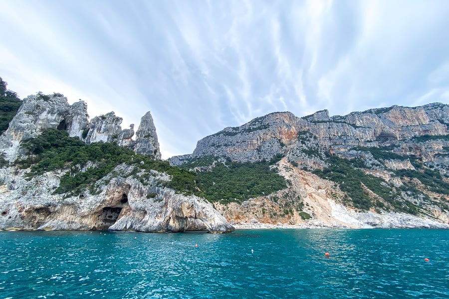 Emerald waters fringe Sardinia’s spectacular Gulf of Orosei as iconic Aguglia rises majestically behind Cala Goloritzé.