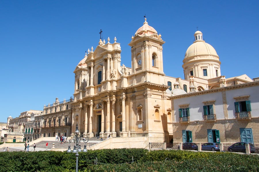 Noto’s Cathedral, highlight of a Sicily road trip, gleams under a blue sky with a cream-coloured stone. 
