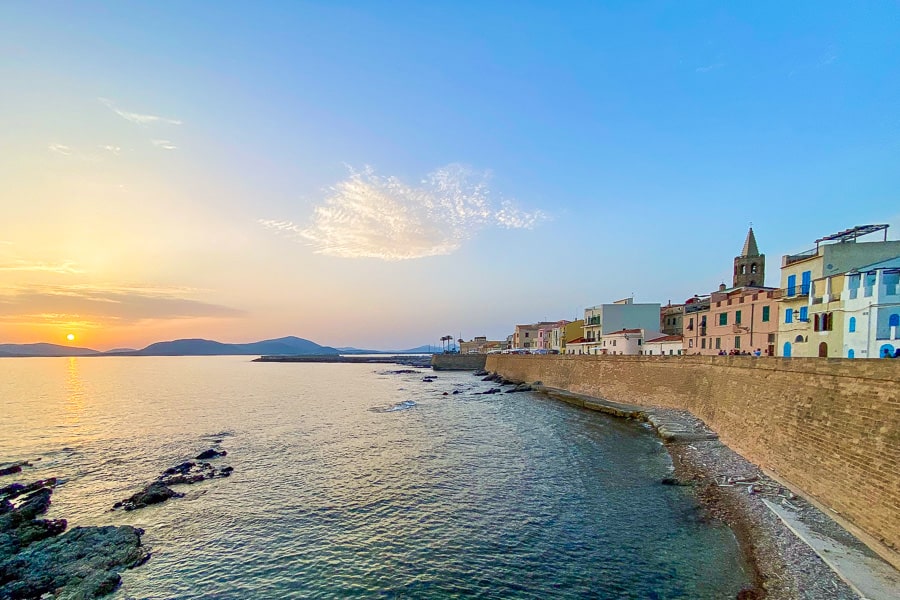 Stunning views of a beautiful orange sunset and Alghero’s imposing city walls – one of many reasons to visit Sardinia.