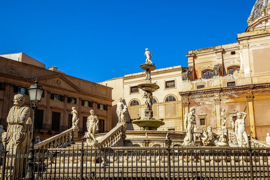 Marble statues of naked men and women adorn a fountain in Palermo Sicily.  