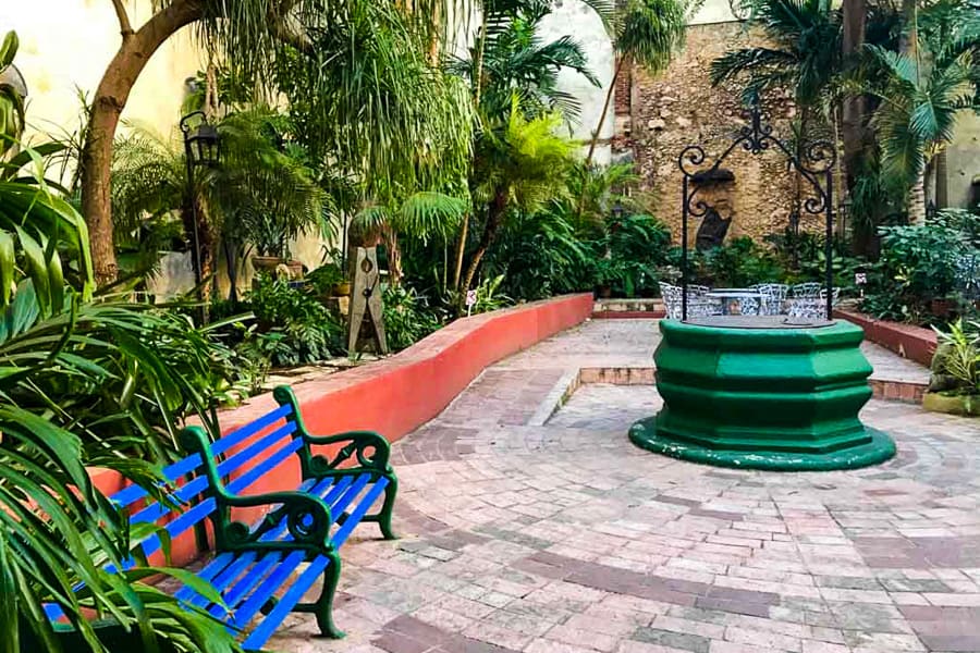 Cuba highlights: A colourful courtyard with blue benches and a green fountain in Havana’s Old Town.